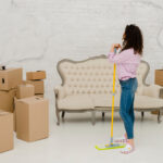 Femme nettoyant un sol d’appartement vidé, symbolisant les étapes du nettoyage après déménagement pour récupérer une caution ou valoriser un bien immobilier.