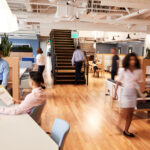 Vue d’un open space moderne avec collaborateurs travaillant en équipe, illustrant l’aménagement d’espaces ouverts, productivité et collaboration en entreprise.